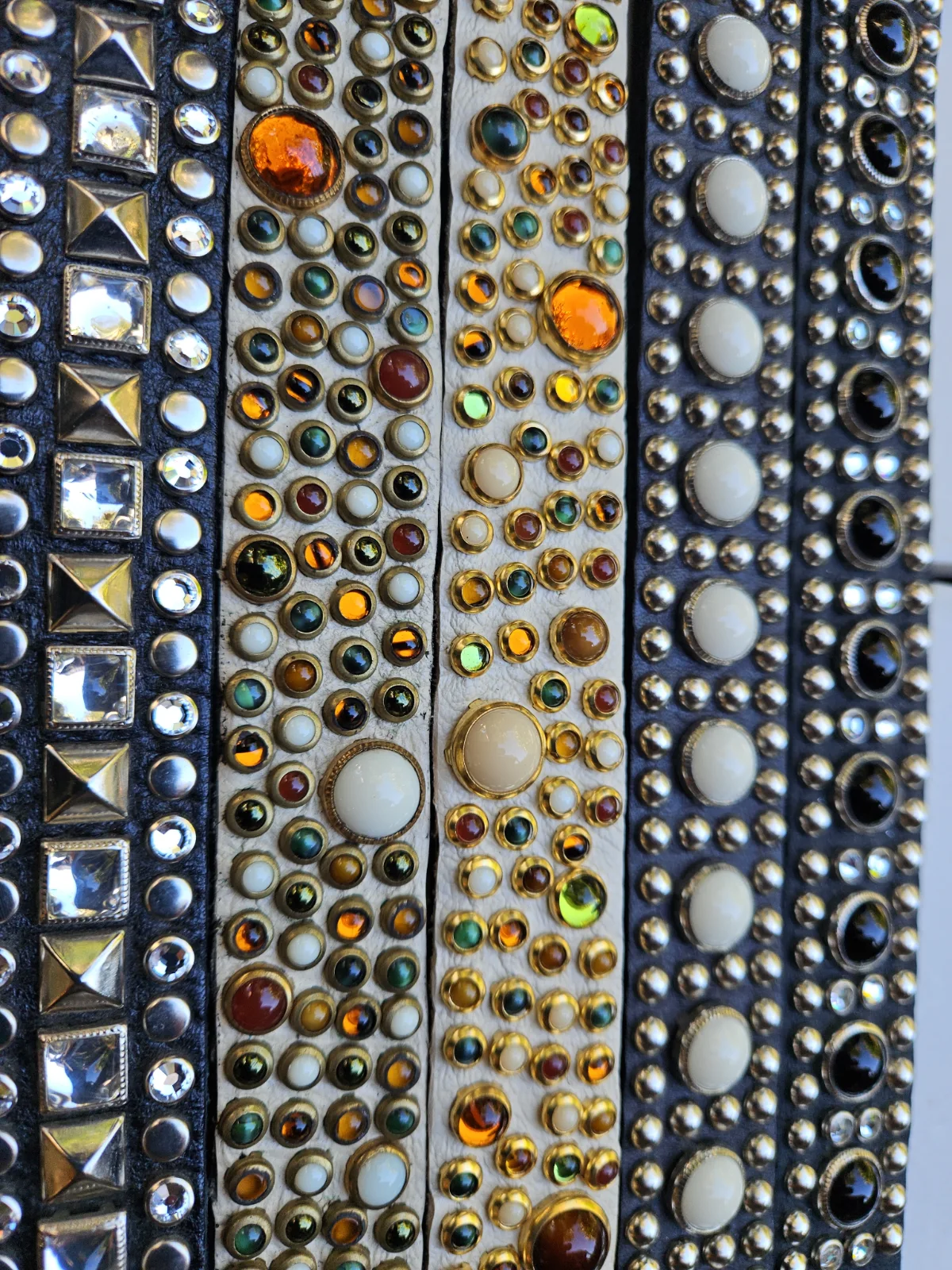 Close-up of RN Design collars with metallic and colorful stud patterns
